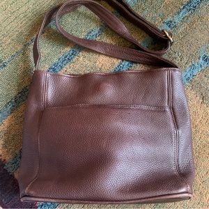 The Coach bag boasts of soft pebbled brown leather and gold hardware